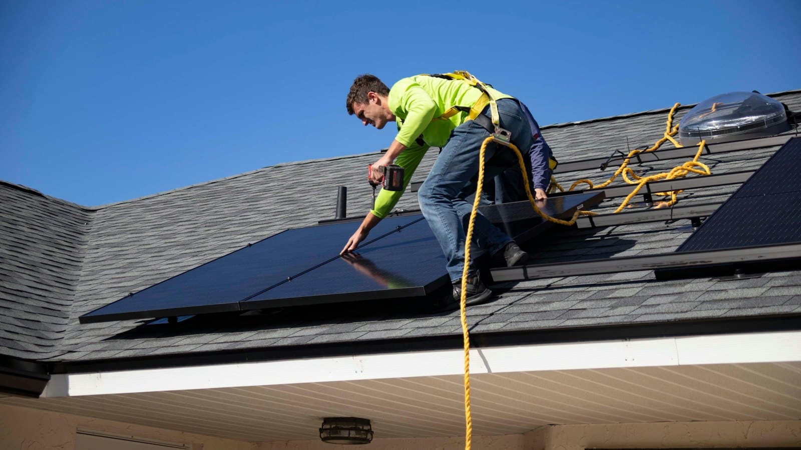 A solar installer on a roof fitting panels