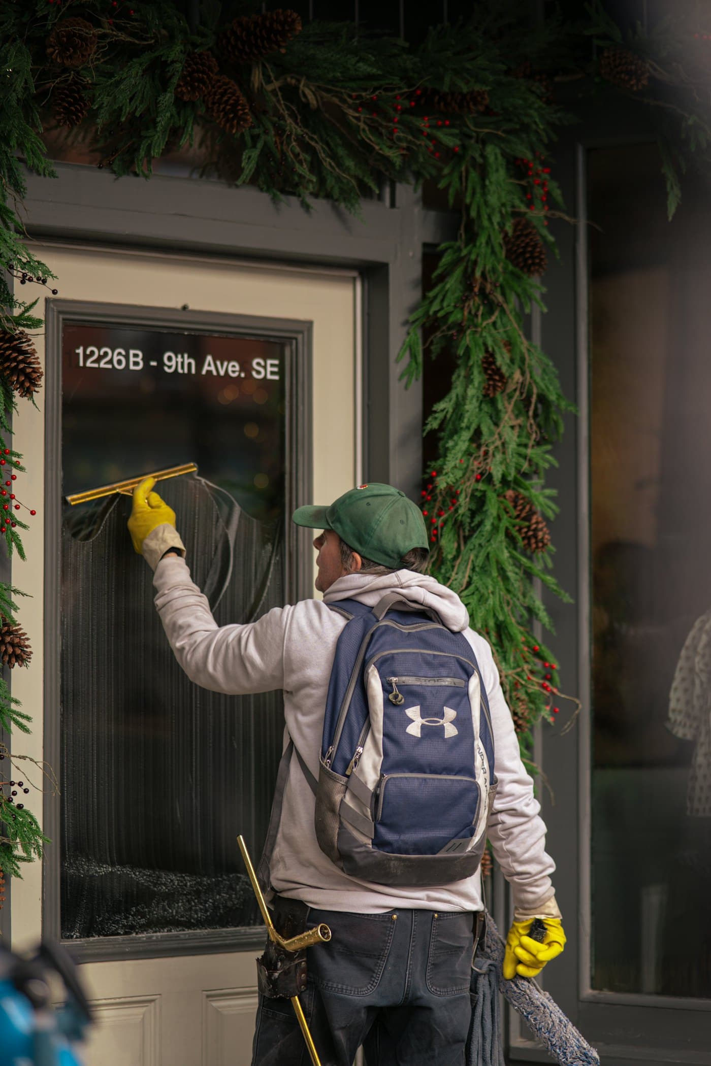 A window cleaner with a squeegee on a shop front door